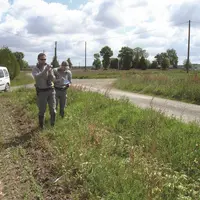 deux agents de l'OFB en bordure de champ à côté d'une route