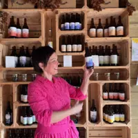 Jeune femme présentant des produits issus de la pomme comme une bouteille de jus
