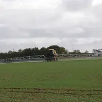 un tracteur traite un champ avec des pesticides