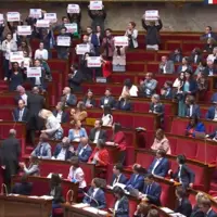 Députés LFI brandissant des pancartes à l'assemblée nationale