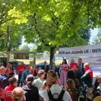 des manifestants avec une banderole en arrière-plan
