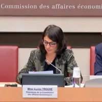 trois personnes assises devant un micro
