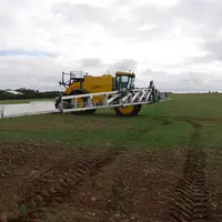 tracteur épandant des pesticides dans un champ