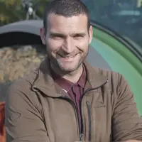 Benoît Merlo, polyculteur-éleveur bio, devant son tracteur.