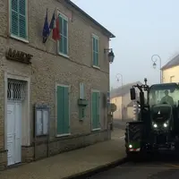 tracteur passant devant une mairie dans un village