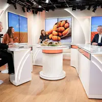 Plateau de télévision avec cinq personnes assises derrière un pupitre