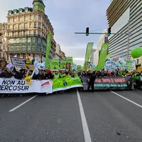 Des agriculteurs manifestant avec des banderoles contre l'accord UE-Mercosur dans les rues de Bruxelles