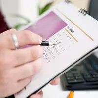 Une personne entoure la date d'un calendrier
