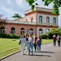 des élèves marchent sur une allée avec un bâtiment en briques en arrière-plan
