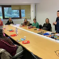 des femmes assises autour d'un bureau et une femme debout