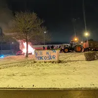 Tracteurs sur un rond point, avec un feu, et une banderole "non au Mercosur"
