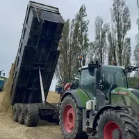 Tracteur déversant du maïs ensilage dans un silo