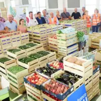 cagettes de fruits et légumes avec un groupe de personnes en arrière-plan