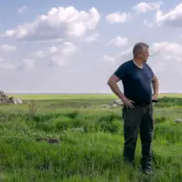agriculteur dans son champ avec débris au sol