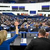 Députés européens vus de dos et levant la main pour voter lors d'une session du Parlement européen