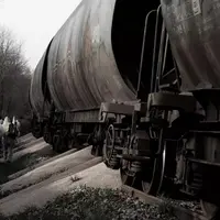 Militants en combinaison blanche à côté d'un train de marchandises dont une partie de la cargaison de blé a été deversée sur les rails.