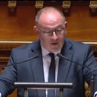 un homme au micro dans l'enceinte du Sénat