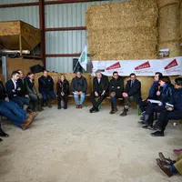 La ministre de l'Agriculture Annie Genevard assise devant de la paille sur une exploitation ovine en Haute-Marne, avec des représentants syndicaux des