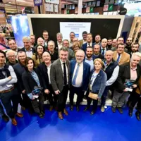 un groupe de personnes posant pour la photo prise d'en haut sur un stand du salon de l'agriculture