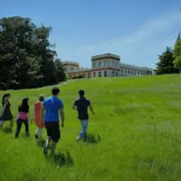 Jeunes gens courant dans l'herbe avec en fond une vieille bâtisse