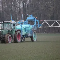 tracteur épandant de l'engrais dans un champ