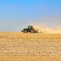 Tracteur dans un champ très sec après la moisson