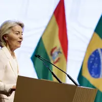 Ursula von der Leyen présidente de la Commission européenne devant les drapeaux du Mercosur et du Brésil