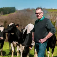 Damien Lacombe posant devant ses vaches en extérieur