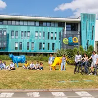 étudiant posant devant un bâtiment scolaire où est mentionné ESA