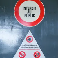 panneau interdit au publi et un autre dander pesticides affichés sur une porte