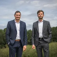 Deux hommes en costume dans un champ