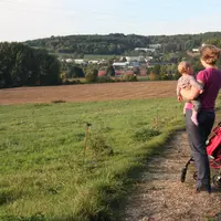 Femme avec son bébé dans les bras en promenade dans les champs