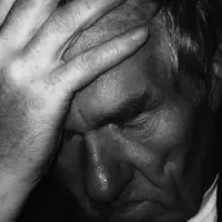 homme se tenant la tête dans la main