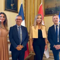 Deux hommes et deux femmes posent pour la photo avec des derapeaux en arrière-plan