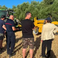 La préfète avec des représentants agricoles et un pompier devant des machines agricoles.