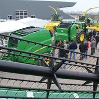 Concessionnaire John Deere avec des visiteurs en extérieur devant des machines agricoles.