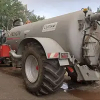 citerne agrciole arrêtée sur une route avec un cmaion de pompiers à côté