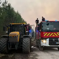 Tracteur ravitaillant un camion de pompier en eau lors de l'incendie en Gironde.