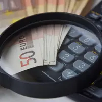 billets de 50 euros avec une loupe et une calculatrice