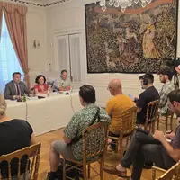 u  groupe de personnes assis derrière une table répondant à des journalistes