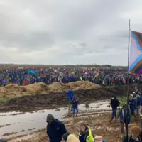 sur un terrain boeux de nombreux manifestants dont certains tiennet des drapeaux