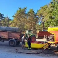 Agriculteur aidant à ravitailler les pompiers en eau dans la forêt de Fontainebleau avec sa tonne à eau.