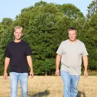 deux éleveurs posent pour la photo dans un  champ
