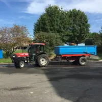 Tracteur avec une benne dans la cour d'une coopérative.