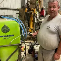 Avec une lance dans chaque main, Gabriel Astier peut arroser les plants depuis son tracteur.