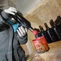 Cachetage des bouteilles à la cire au château Le Puy (Famille Amoreau). Production de vins naturels dans le Bordelais. Méthode ancienne traditionnelle