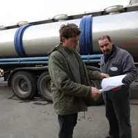 Viticulture. Commercialisation du vin. Vente en vrac au négoce. Contrôle et signature d'un bon de transport après chargement de vin dans un camion cit