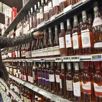 client de supermarché dans un rayon vins. Grande distribution. magasin Carrefour. jeune consommateur dans une grande surface.
