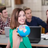 junge frau zeigt weltkugel