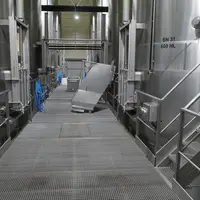 Chai de la cave coopérative de Tutiac. Cuves en inox de 600 hl, goulotte pour décuvage, vis sans fin sous le sol grillagé pour